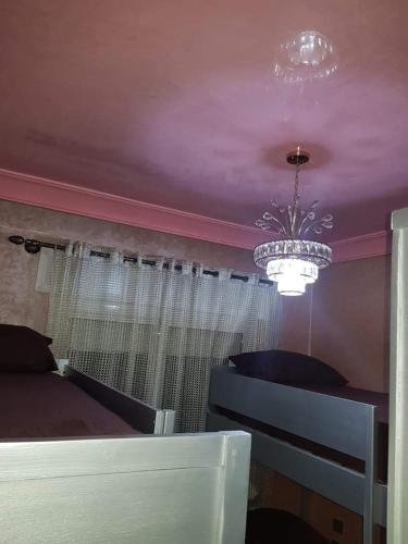 a bedroom with a bed and a chandelier at Appartement A1 ARENA DE MARTIL in Martil