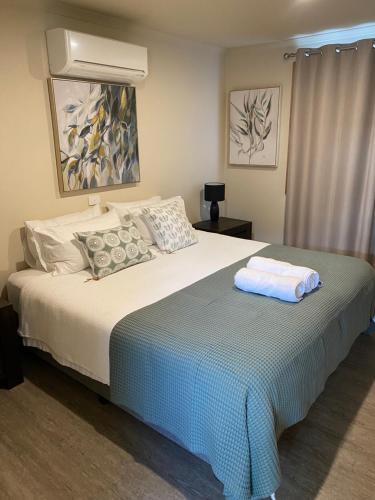 a bedroom with a bed with a blue blanket at Daysend Cottages in Merrijig