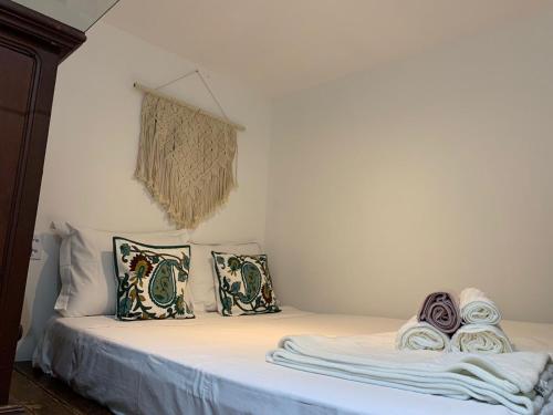 Una cama con almohadas y toallas encima. en Tereze House, en Río de Janeiro