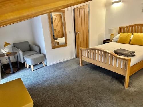 um quarto com uma cama grande e uma cadeira em Brechin Townhouse - Cathedral View em Brechin