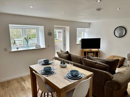a living room with a table and a couch at Brechin Townhouse - Cathedral View in Brechin