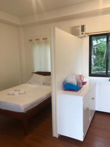 a small bedroom with a bed and a cabinet at MLB Beachfront Apartment in Siquijor