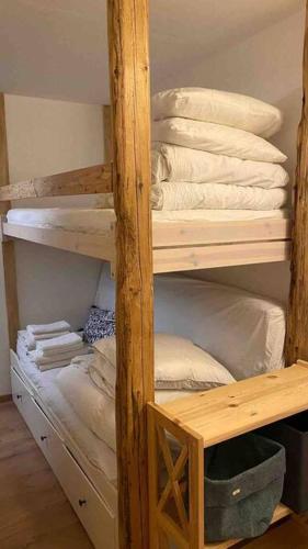 - un lit superposé en bois avec des oreillers et des serviettes blancs dans l'établissement Cosy duplex in Chatel centre with indoor Parking, à Châtel