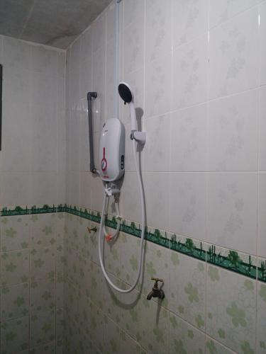 a shower in the corner of a bathroom at Dhia Irdina Homestay in Paya Rewak