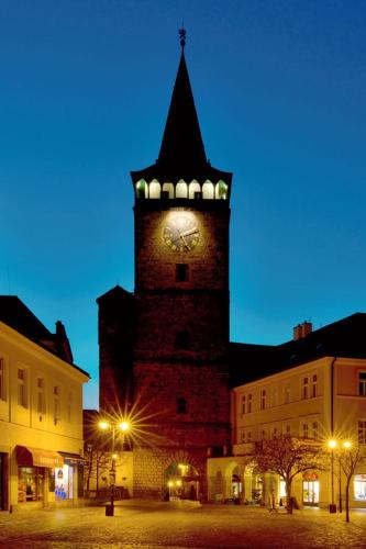 a tall clock tower with a clock on it at P&P Jičín Apartments - soukromé 2-3 lůžkové pokoje s vlastní kuchyní a koupelnou in Jičín