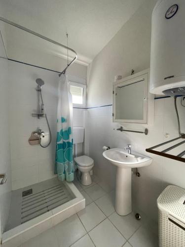 a bathroom with a sink and a shower and a toilet at Adriatic Family House in Utjeha