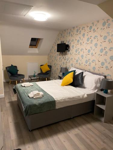 a bedroom with a large bed with yellow and blue wallpaper at Rehoboth guest house in Manchester