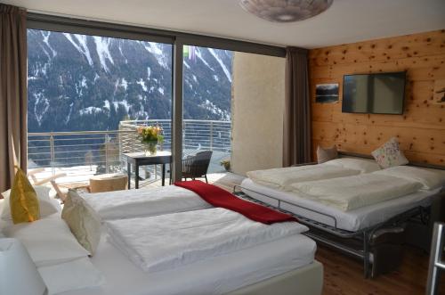 a bedroom with two beds and a large window at Fior Tamion in Vigo di Fassa