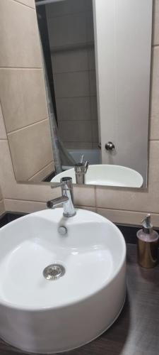 a bathroom with a white sink and a mirror at Linda habitacion in Santiago