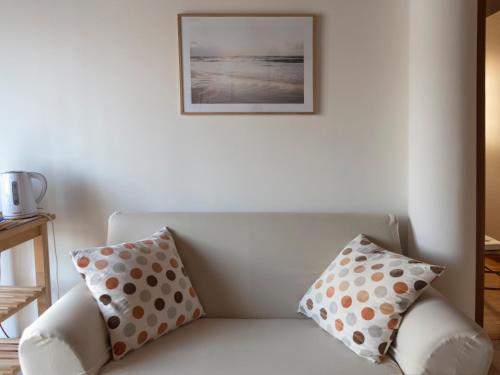 a white couch with polka dotted pillows on it at Appartamento ISOTTA in Lugo