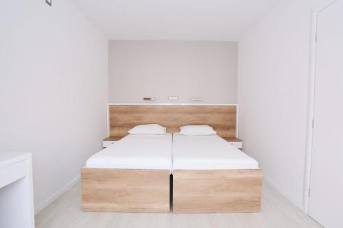 uma cama num quarto com paredes brancas em APARTMENTS LA NATURE MOSTAR-HODBINA em Mostar