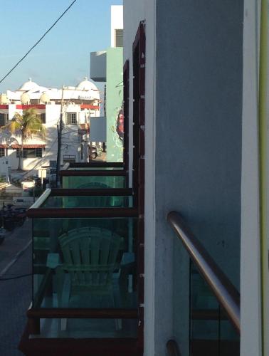 een balkon met een stoel en uitzicht op de stad bij Hotel Isleño in Isla Mujeres