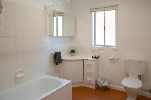 a bathroom with a tub and a toilet and a sink at Settlement Lodge in Mount Buller