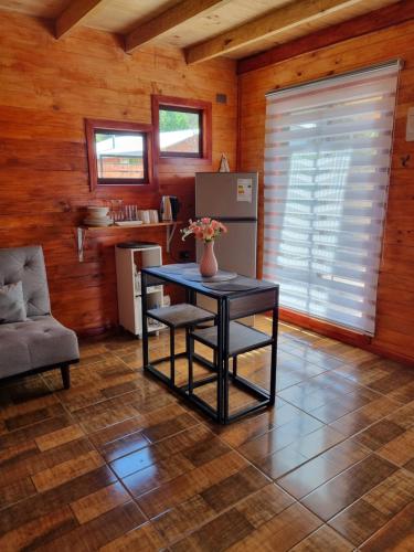 a dining room with a table and a refrigerator at Alojamiento Pamela in Coñaripe