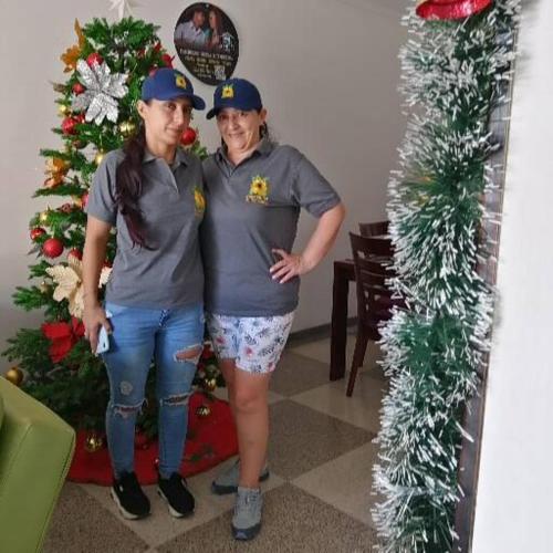 two women standing in front of a christmas tree at Casa Villavicencio in Villavicencio