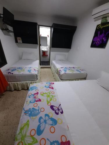 a room with three beds in a room at Casa Villavicencio in Villavicencio