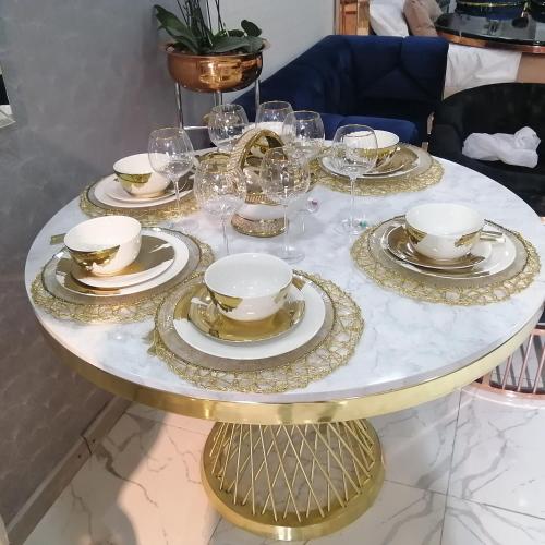 a gold and white table with plates and glasses on it at Casa Villavicencio in Villavicencio