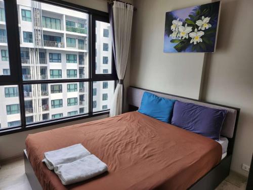a bedroom with a bed and a large window at The base in Pattaya