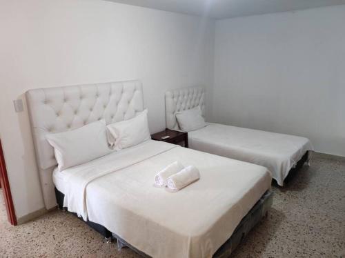 Dos camas en una habitación de hotel con toallas. en RH01 Apto en Riohacha con vista a la playa, la mejor zona de la ciudad, genial para trabajar o estar con la familia, en Ríohacha