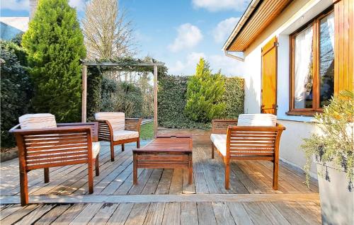 eine Terrasse mit 4 Stühlen, einem Tisch, einem Tisch und Bänken in der Unterkunft Awesome Home In Gonneville-S-Honfleur in Gonneville-sur-Honfleur