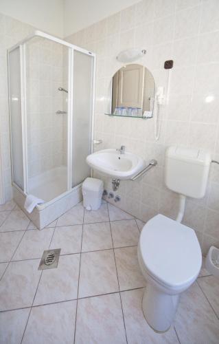a bathroom with a toilet and a shower and a sink at Hotel Astoria in Balatonfüred