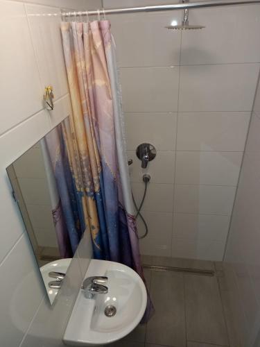 a bathroom with a sink and a shower and a mirror at Neubau Appartement mit Terasse, privater Eingang,Parkplatz,Küche in Fürth