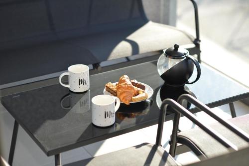 a coffee table with a plate of food and two cups at Solaris Lux Apartments in Kotor