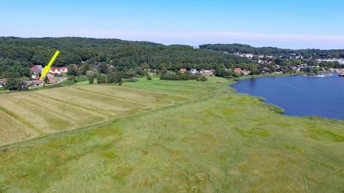 an aerial view of a field next to a lake at WG Bernstein - Reetdachhaus - Ruhe und Seeblick in Ostseebad Sellin