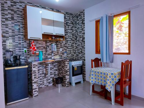 a kitchen with a table and a table and a stove at Aconchego na Chapada in Lençóis