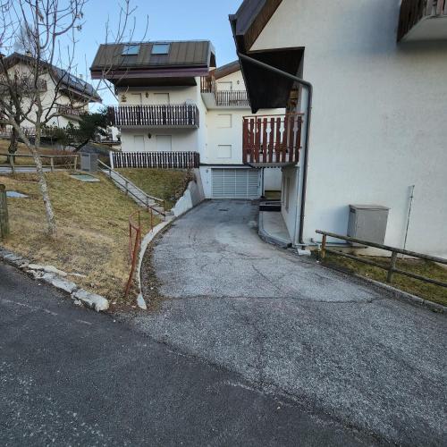 an empty driveway to a house with a balcony at La Vita in Ravascletto