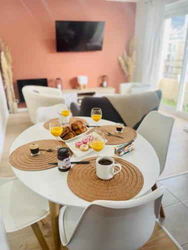 - une table blanche avec des verres de jus d'orange et de la nourriture dans l'établissement Le Terra-Cota 3 Ch privées 10' Gare-Port et Plage, WFI, Cosy, à Toulon