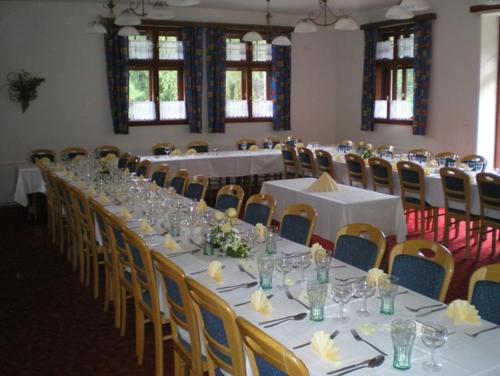 a long table in a room with tables and chairs at Penzion U Ráztoky in Rusava