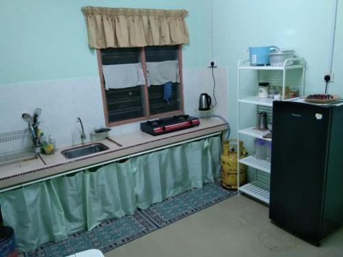 uma cozinha com um lavatório e uma janela em Ruhani Homestay 2 Kota Bharu Cheap and Comfortable em Kota Bharu
