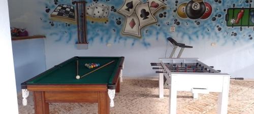 two pool tables in a room with clocks on the wall at POUSADA RECANTO SÃO JORGE in Águas de Lindóia