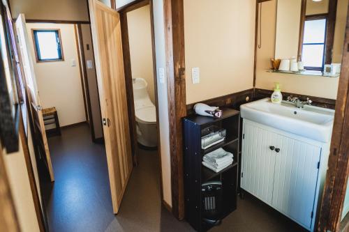 een badkamer met een wastafel en een toilet bij Guest House Yonemuraya in Matsue