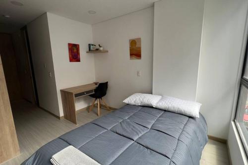 1 dormitorio con cama y escritorio. en Apartaestudio en Chapinero muy bien ubicado, en Bogotá