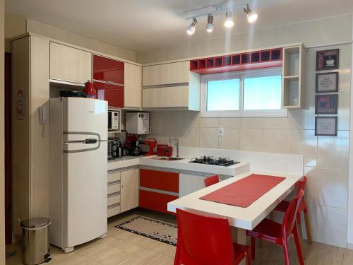 una cucina con frigorifero bianco e armadietti rossi di Apartamento no Beach Place 4 andar da varanda vê o MAR a Cumbuco