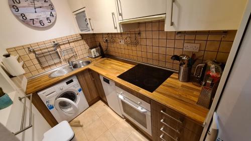 a small kitchen with a sink and a washing machine at 2 bedroom flat on Main Street in Gibraltar