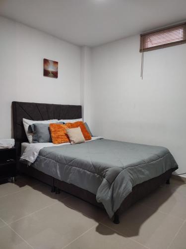 una camera da letto con un grande letto con cuscini arancioni di 302-Cómodo y moderno apartamento de 2 habitaciones en la mejor zona céntrica de Ibagué a Ibagué