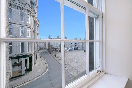 an open window with a view of a city street at Castle Street Apartments ✪ Grampian Lettings Ltd in Aberdeen