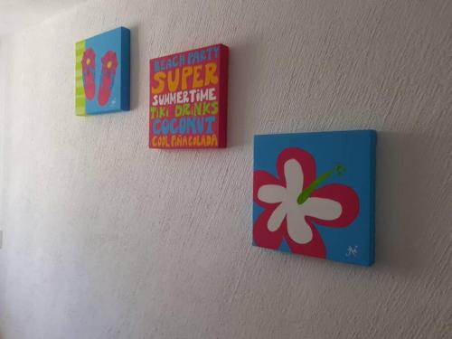 three signs on a wall with a clover on it at Acapulco diamante departamento con playa ecológico in Acapulco