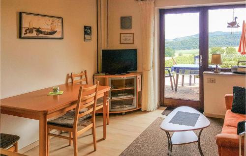 a living room with a dining room table and a television at Cozy Apartment In Medebach-Düdinghausen in Medebach