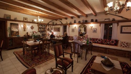 a group of people sitting at tables in a restaurant at Hoyran Wedre Country Houses in Davazlar