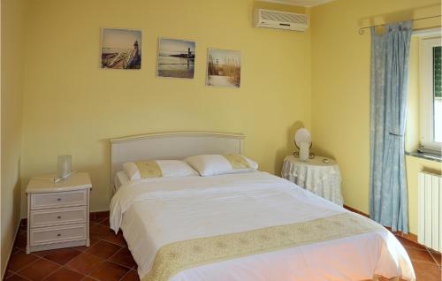 sypialnia z białym łóżkiem i stolikiem nocnym w obiekcie Villa Marino w mieście Tortora