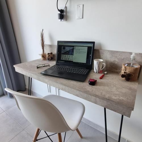 a desk with a laptop computer on top of it at AZ Suites Resistencia in Resistencia