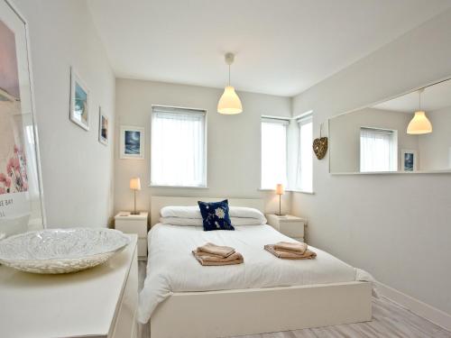 a white bedroom with two beds and a sink at Apartment 7, Ocean 1 in Crantock