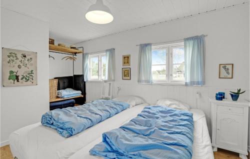 SønderhoにあるNice Home In Fan With 2 Bedrooms And Wifiのベッドルーム1室(大型ベッド1台、青いシーツ付)