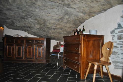 a room with a wooden dresser and a chair at Casa Vacanza La Rocca in Chiesa in Valmalenco
