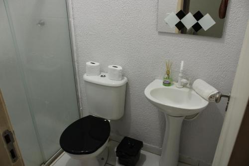 a bathroom with a toilet and a sink at Casa 02 Quartos Condomínio Aceita Pet in Ourinhos