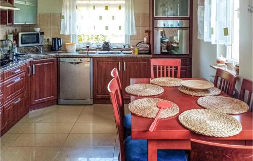 eine Küche mit einem roten Tisch mit Strohhüten darauf in der Unterkunft 3 Bedroom Amazing Home In Parzensko in Nowogródek Pomorski